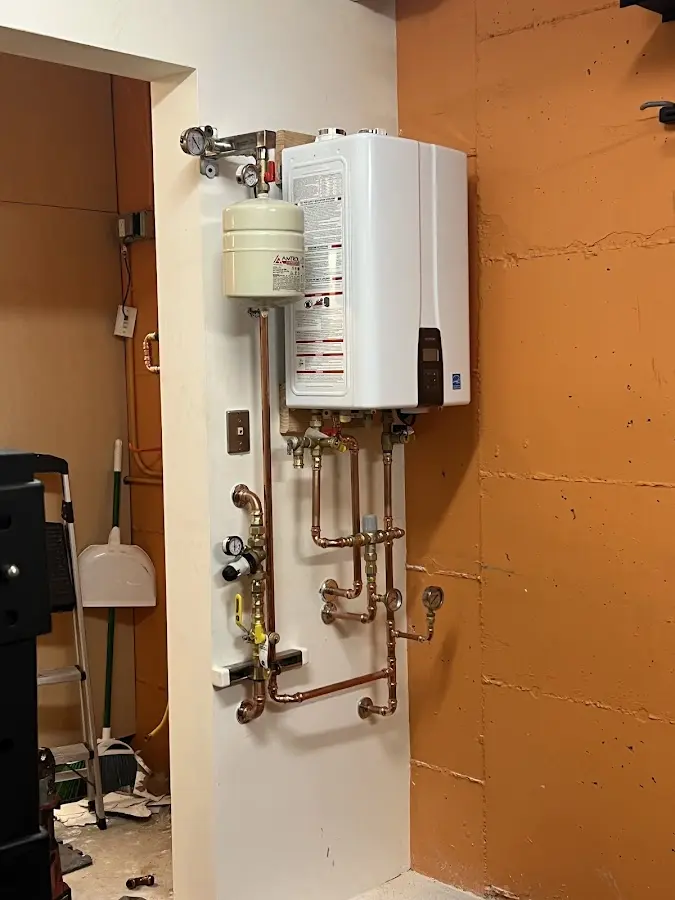 Plumbing technician inspecting water heater connections in Palatine